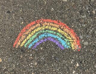 Mädchen*räume Regenbogen Mit bunter Kreide wurde ein Regenbogen auf Asphalt gemalt.