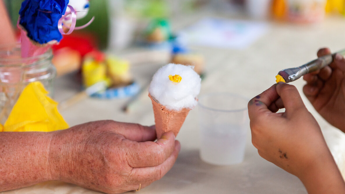 Eine Hald hält ein gebasteltes Eis aus Watte und Papier.