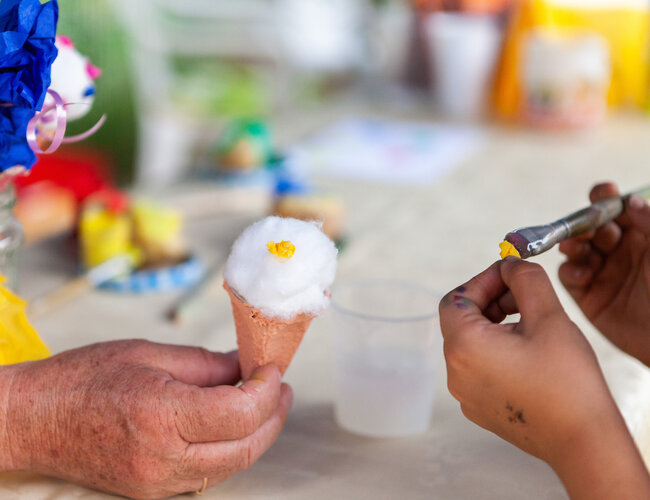 Eine Hald hält ein gebasteltes Eis aus Watte und Papier.