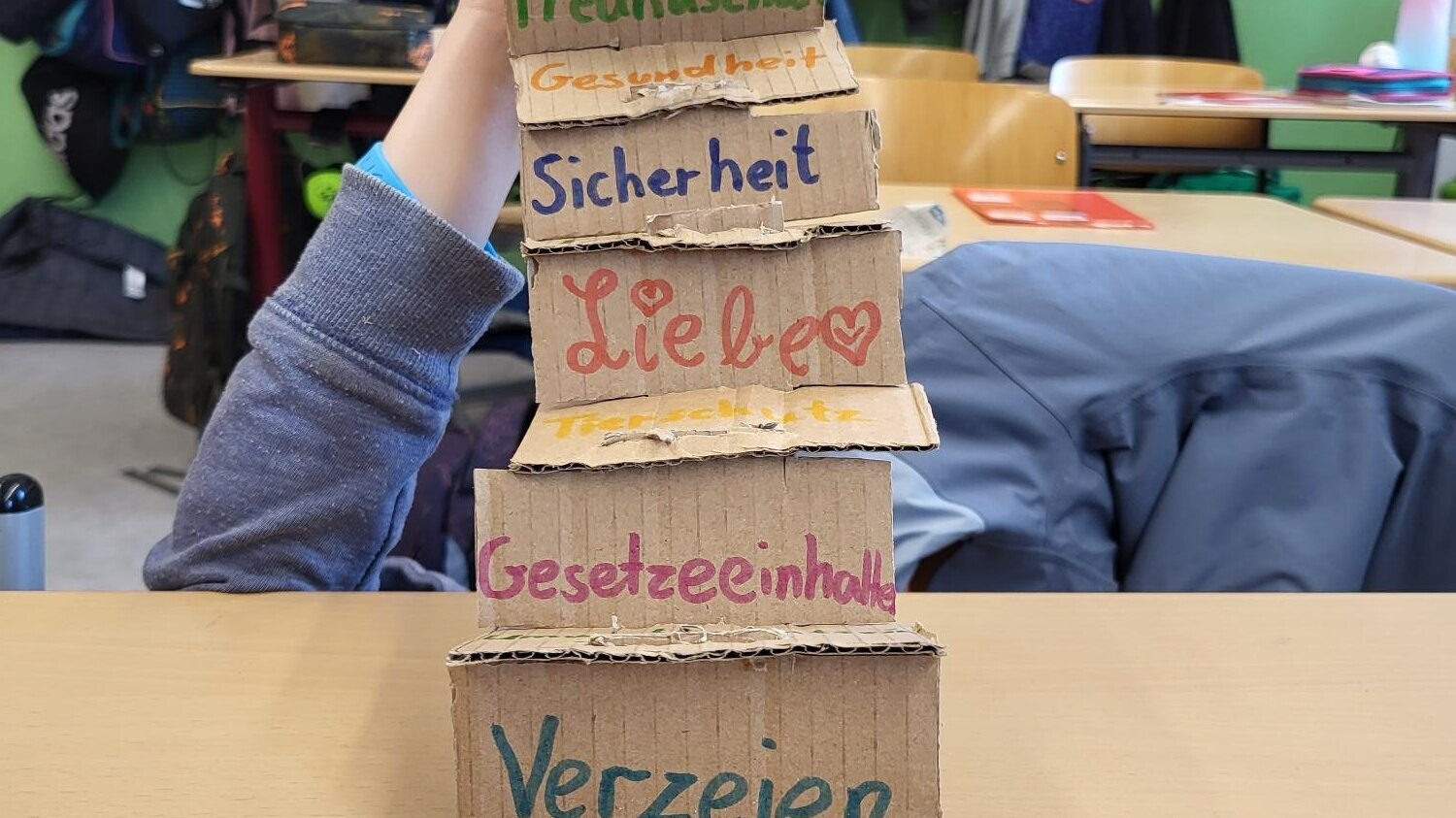 Gebastelter Turm aus Kartonelementen mit verschiedenen Werten