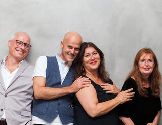 Berliner-Herz-Botschafter*innen An einer Wand lehnen von links: Volker Wieprecht, Rolf Zacherl, Eva Mattes und eine weitere Person.