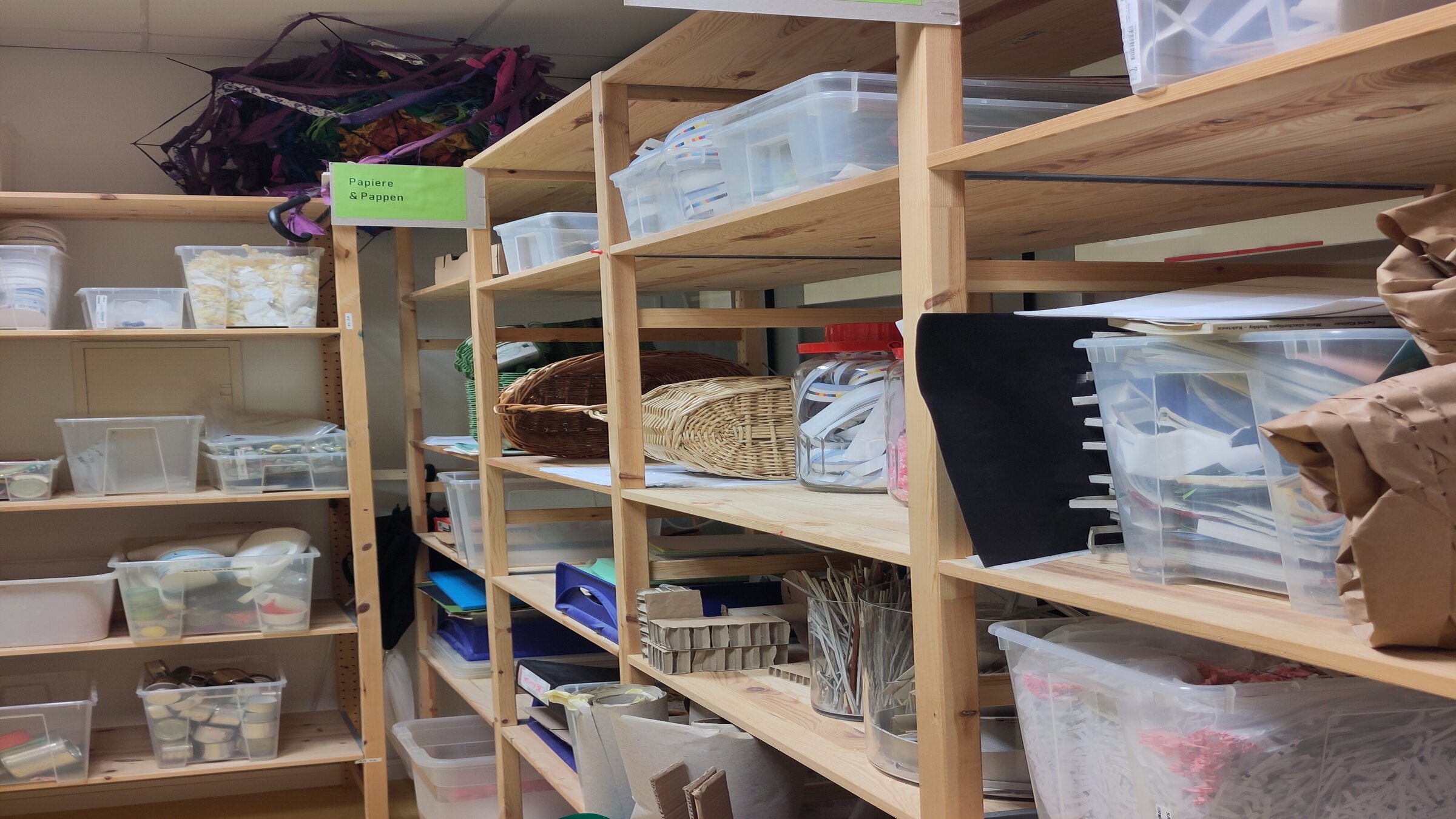 Holzregale mit kreativen Materialien im Atelier