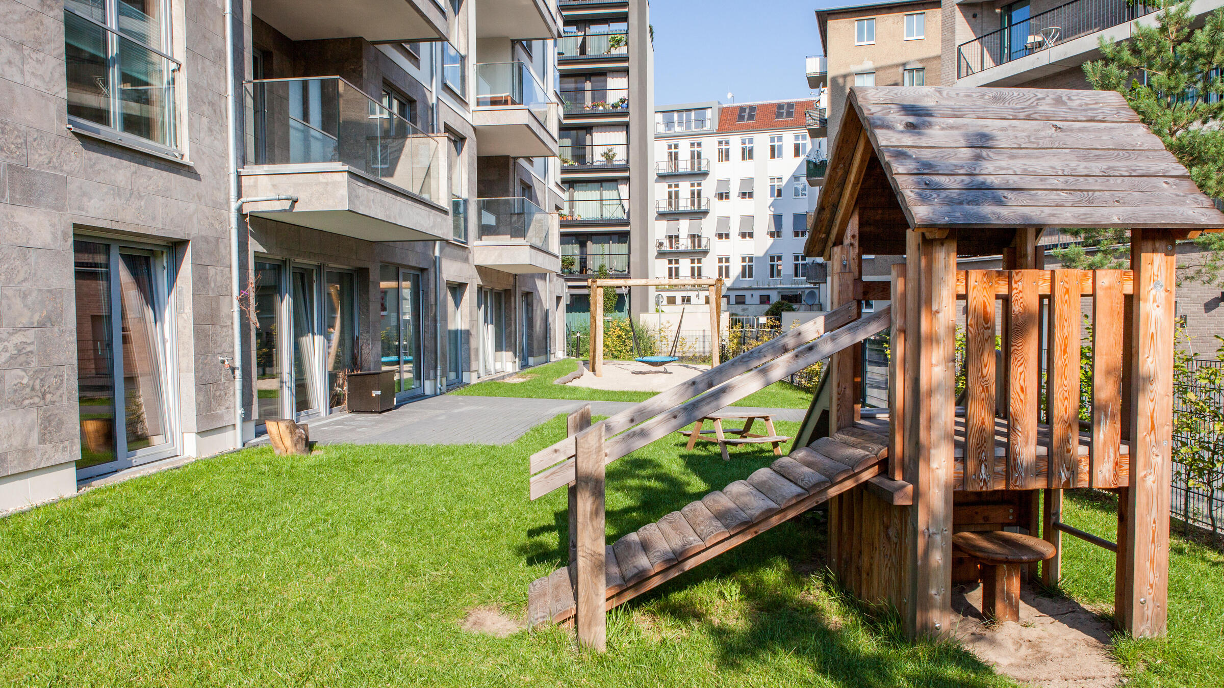 Foto Außenansicht Kita Flottwellstraße Spielplatz mit Haus auf Rasen