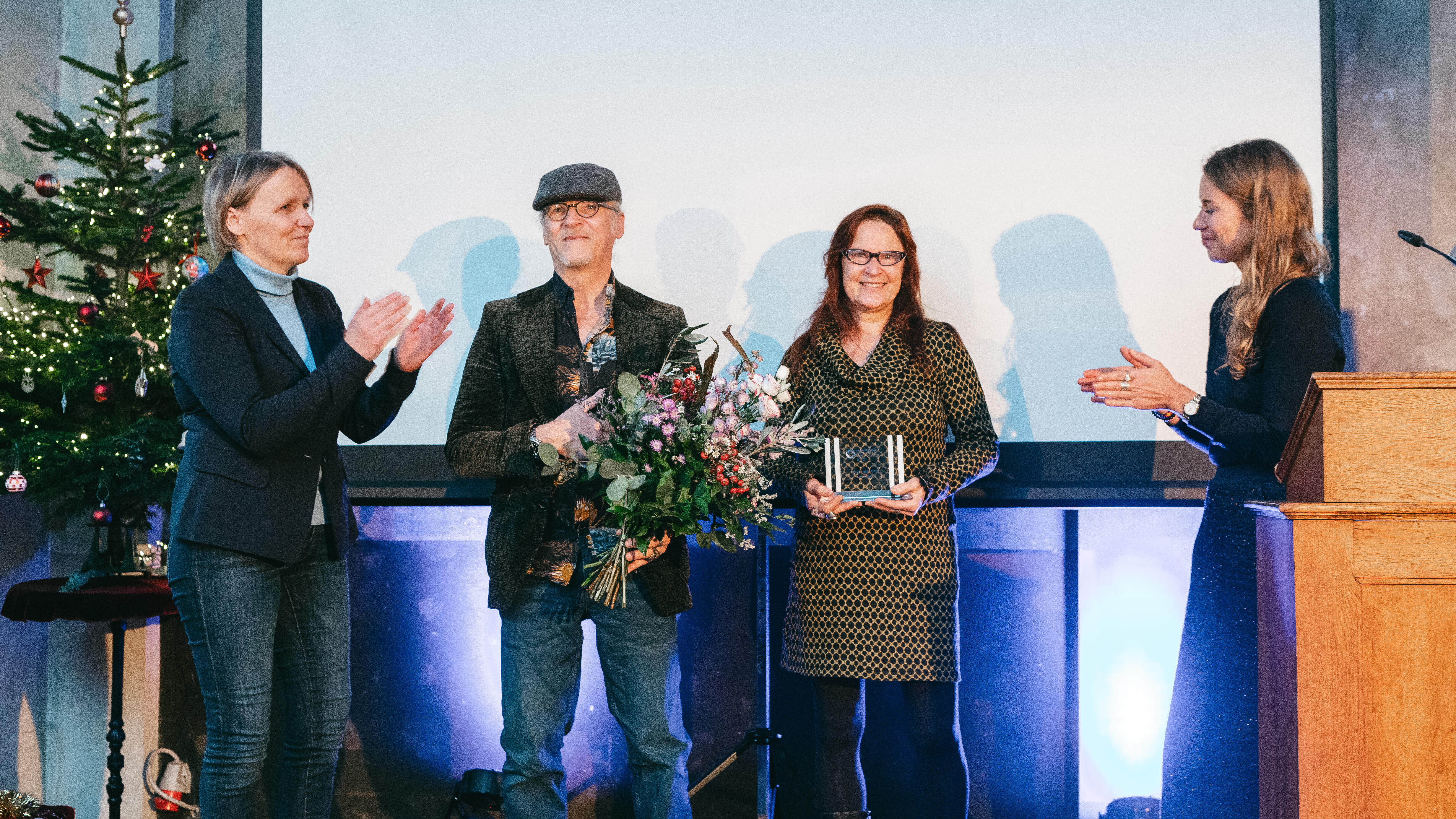 Auf dem Bild sind die Preisträger*innen Birgit und Horst Lohmeyer bei der Preisübergabe zu sehen.