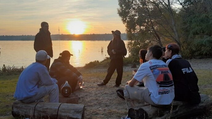 Jugendliche sitzen am See 
