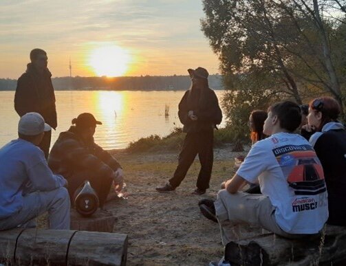 Jugendliche sitzen am See 