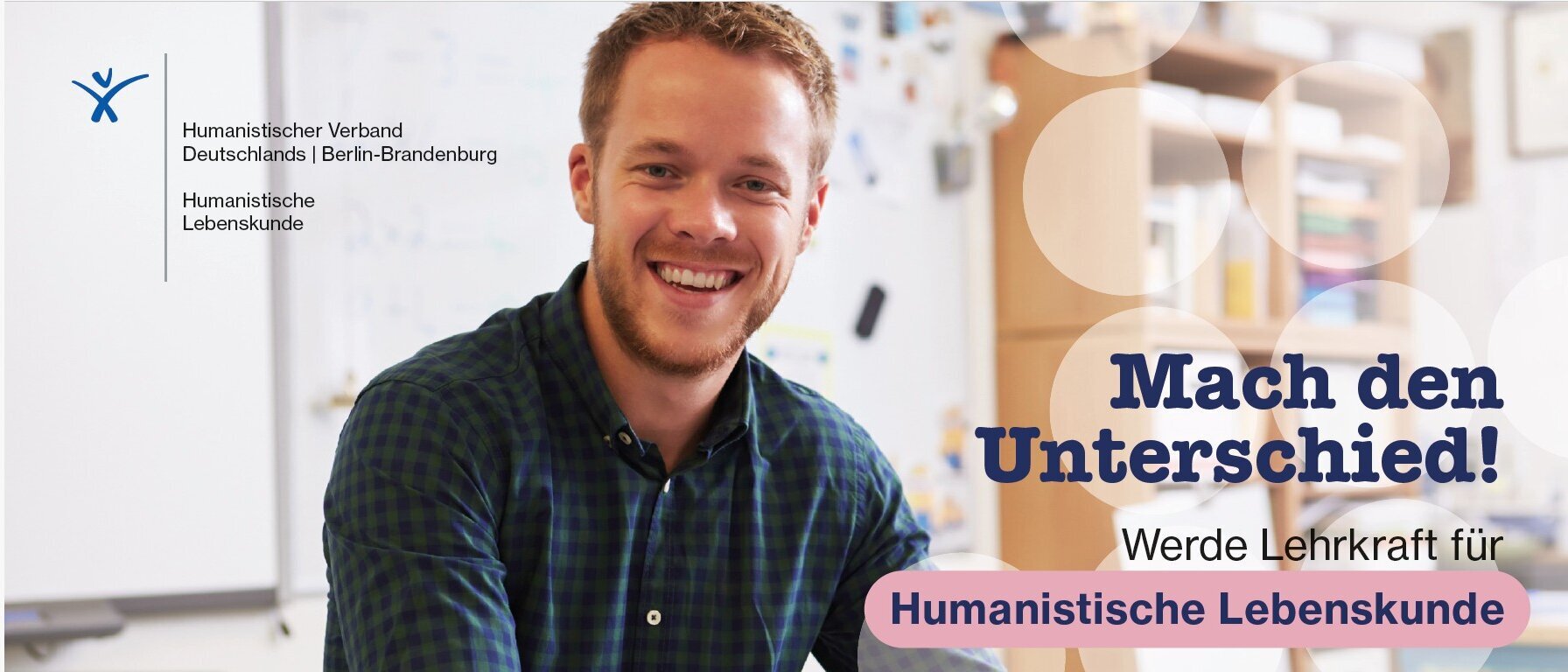 Ein die betrachtende Person anlachender Mann sitzt am Schreibtisch, vor ihm liegen Dokumente. Mit seiner linken Hand hällt er Dokumente, mit seiner rechten einen Stift. Links oben ist das Lebenskunde-Verbandslogo zu sehen. Rechts mittig-unten ist zu lesen: „Mach den Unterschied! Werde Lehrkaft für Humanistische Lebenskunde“.