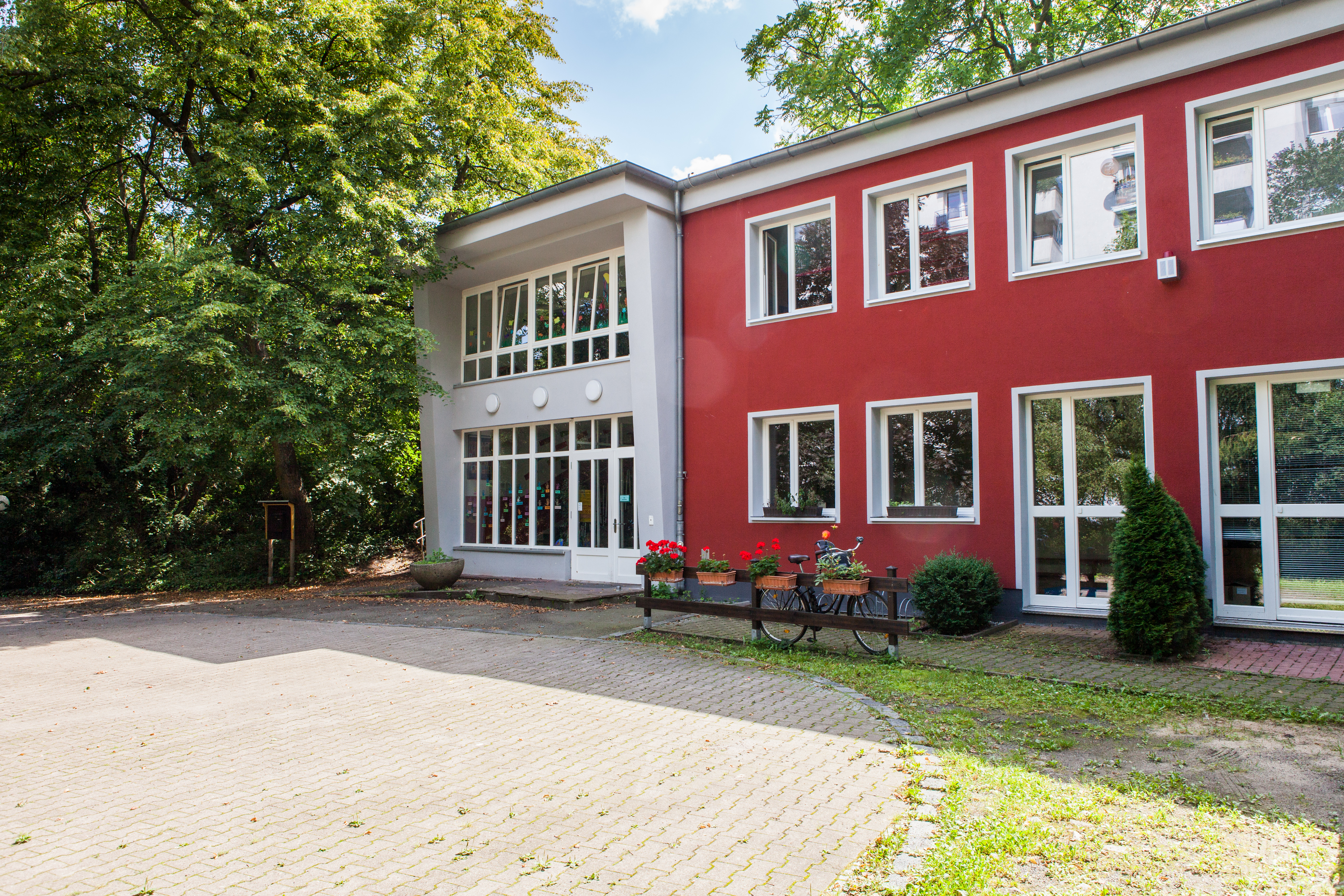 Foto der Außenansicht der Kita Bornsdorfer Straße mit rotem Gebäude