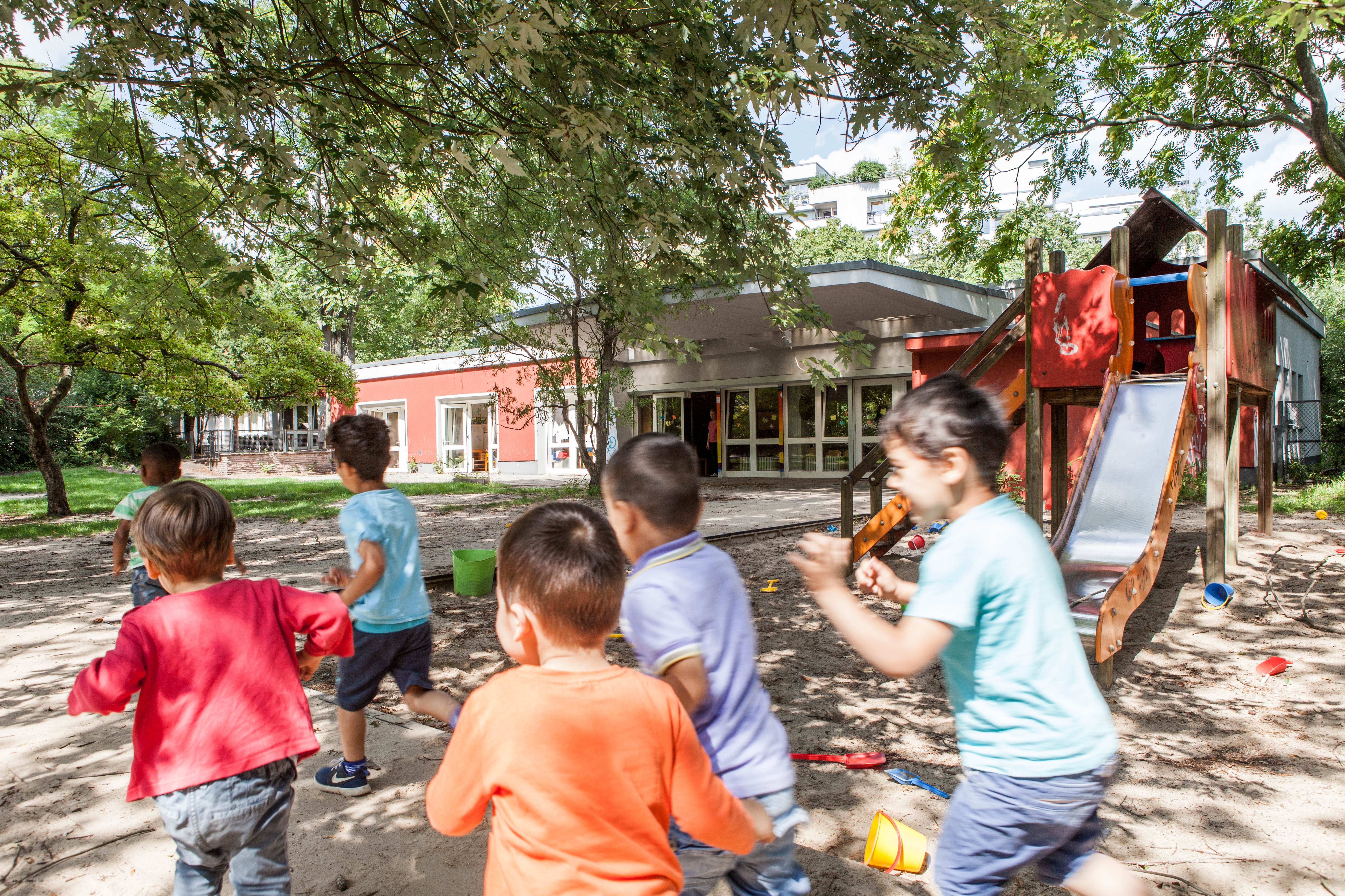 Foto der Außenansicht spielende Kinder, die wegrennen Kita Bornsdorferstraße