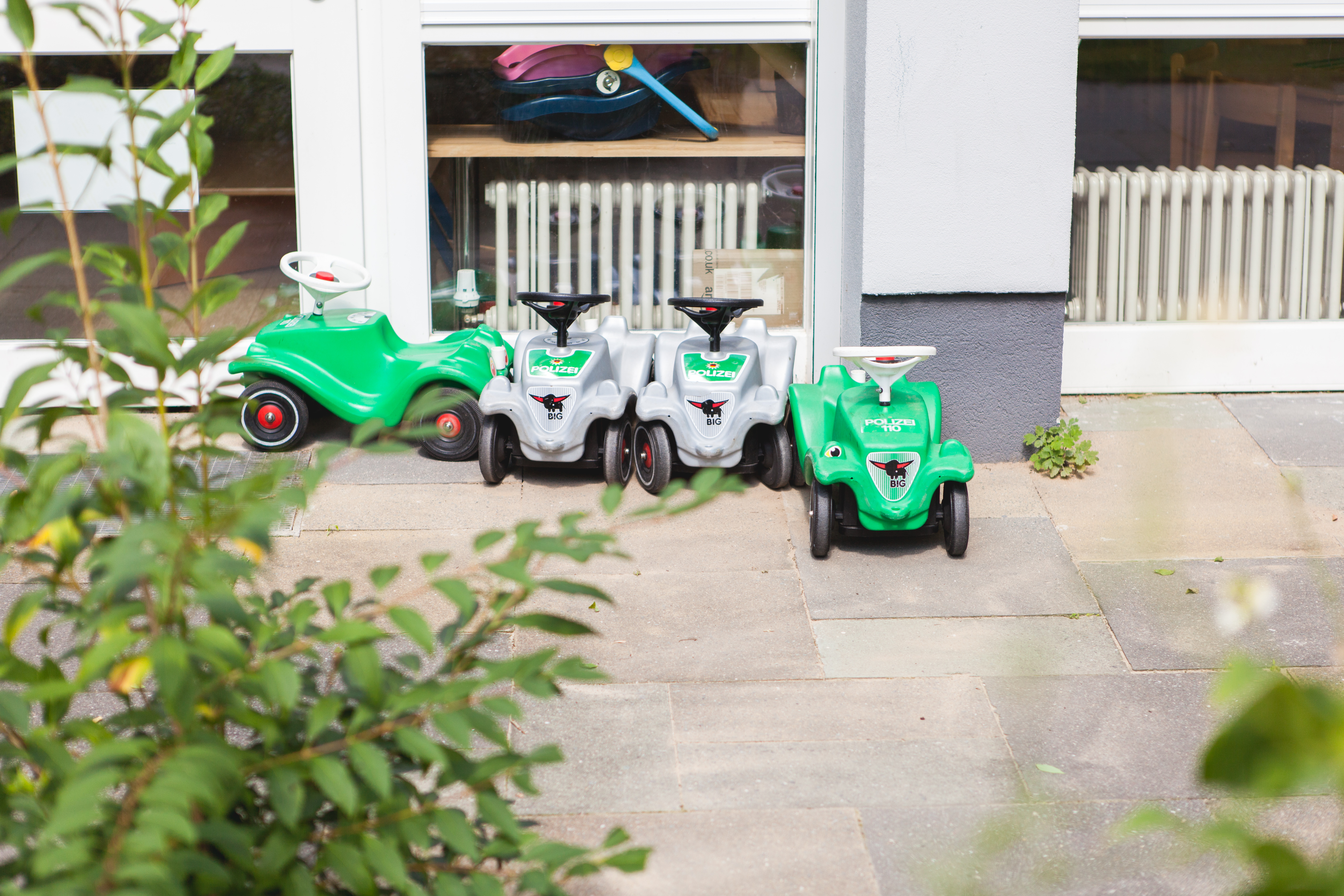 Foto Außenansicht Bobycars in grün und grau Kita Bornsdorferstraße