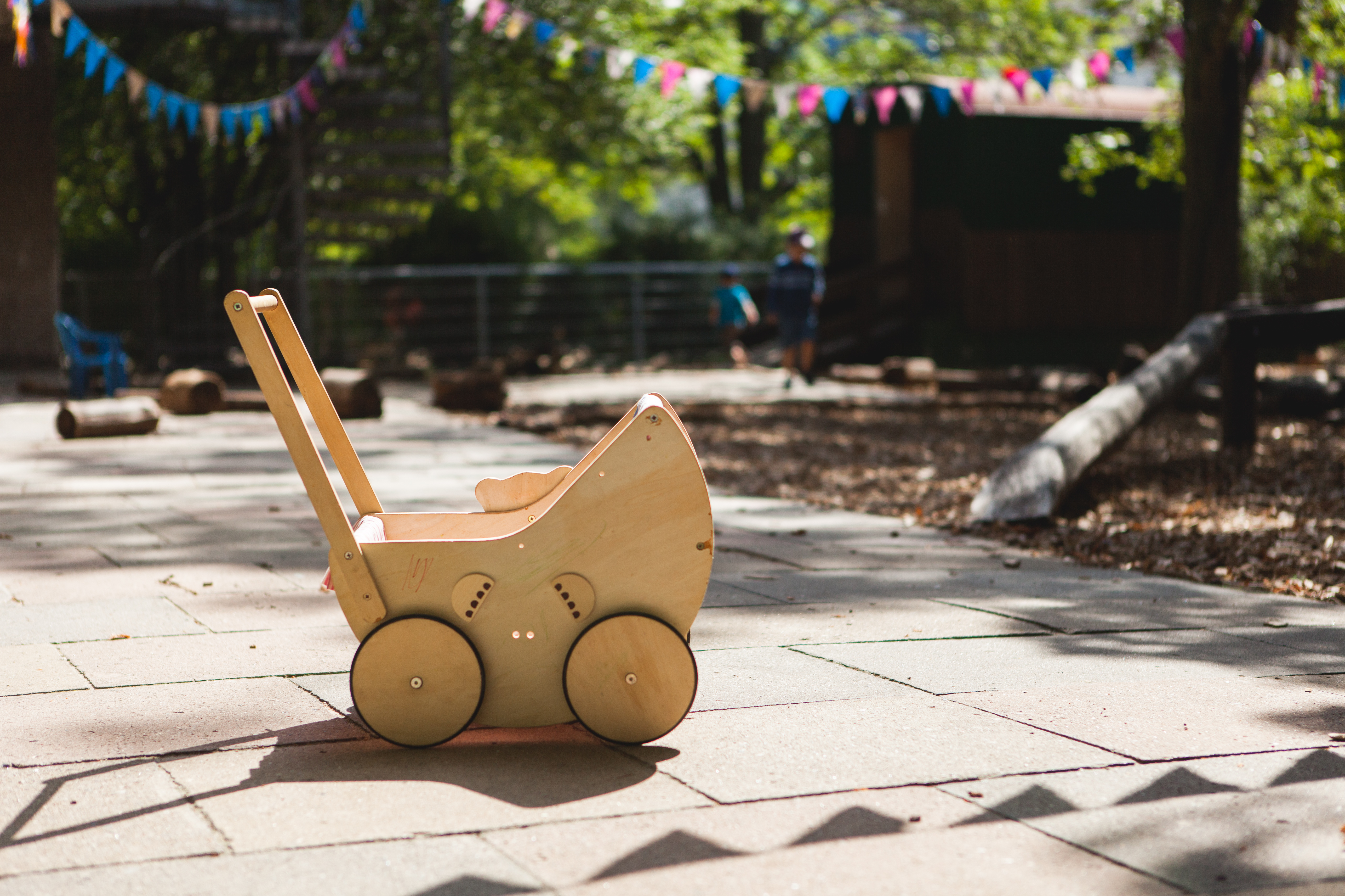 Foto Außenansicht Spielbereich mit Holzkinderwagen Kita Johanna Tech Straße
