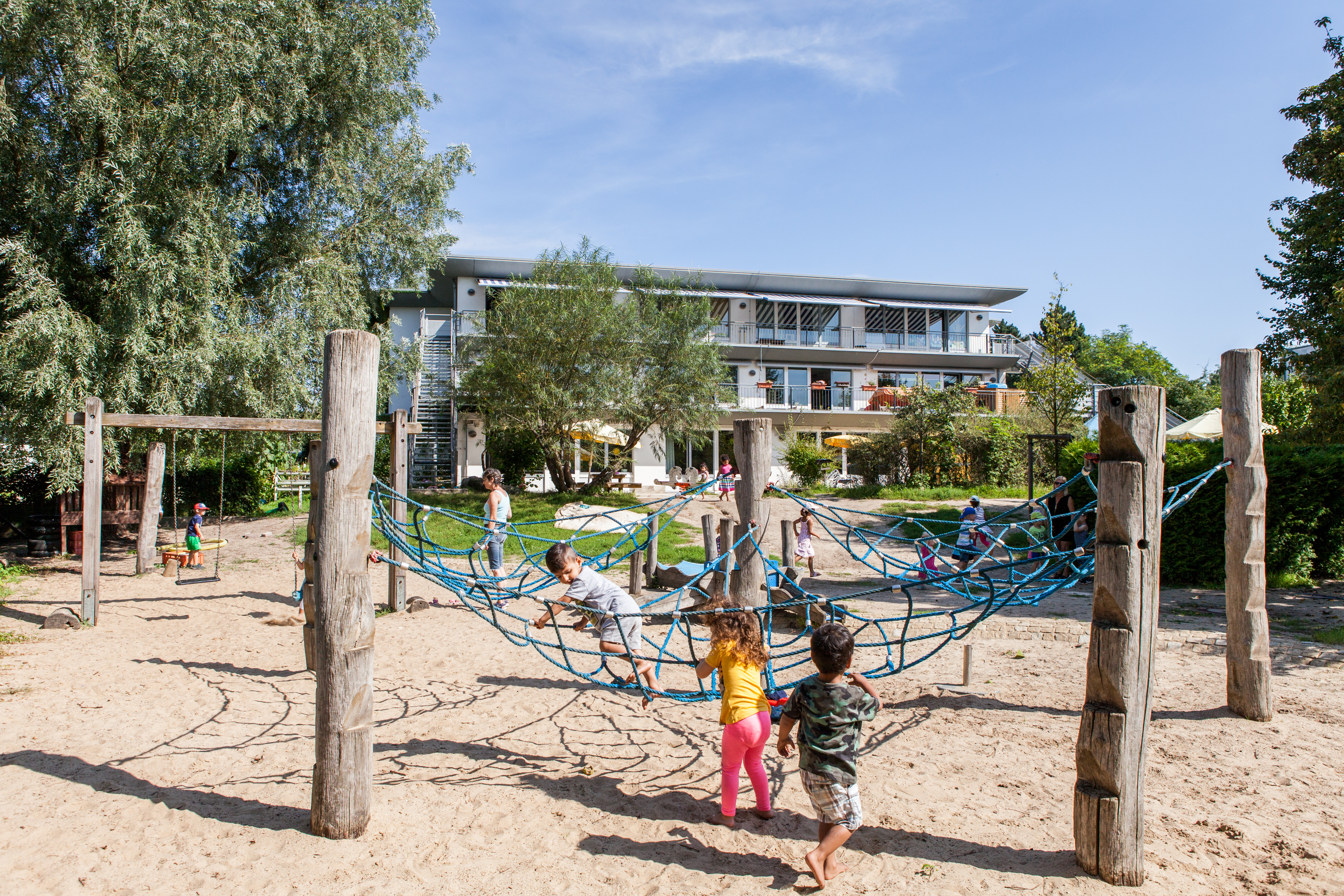 Foto Außenansicht Spielplatz mit Kletternetz Kita Landreiterweg
