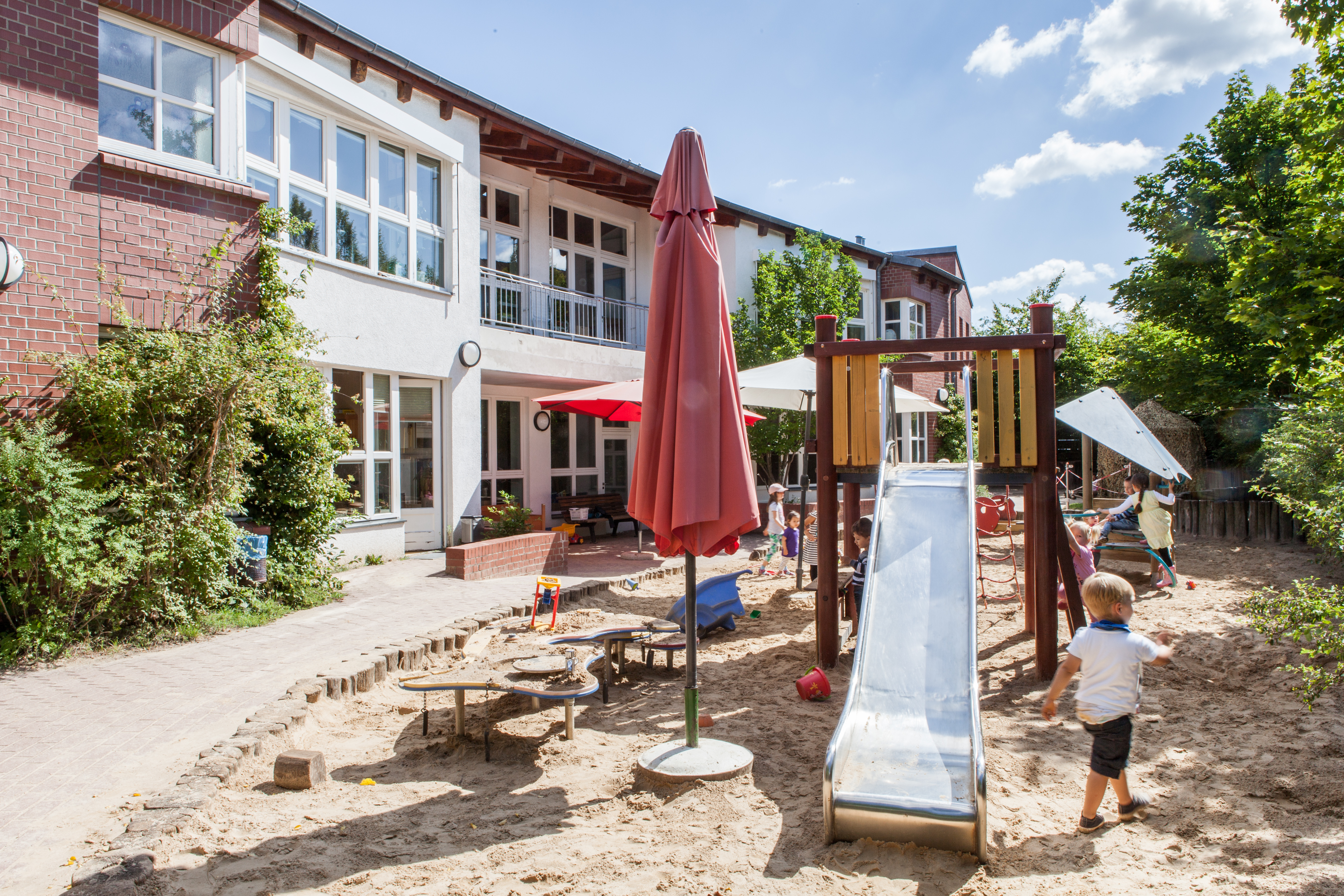 Foto Außenansicht Spielplatz mit Rutsche Kita Michel-Klinitz-Weg