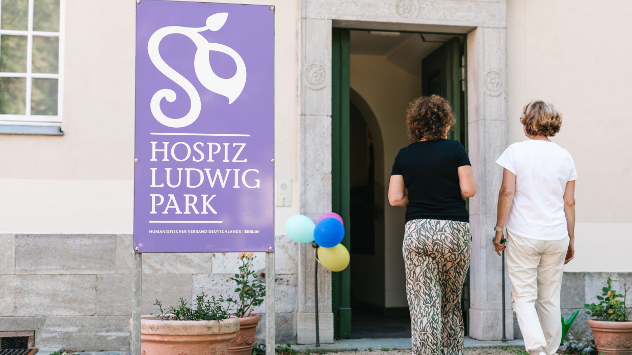 Zwei Personen laufen auf die Eingangstür des Hospizes LudwigPark in Berlin-Buch zu.