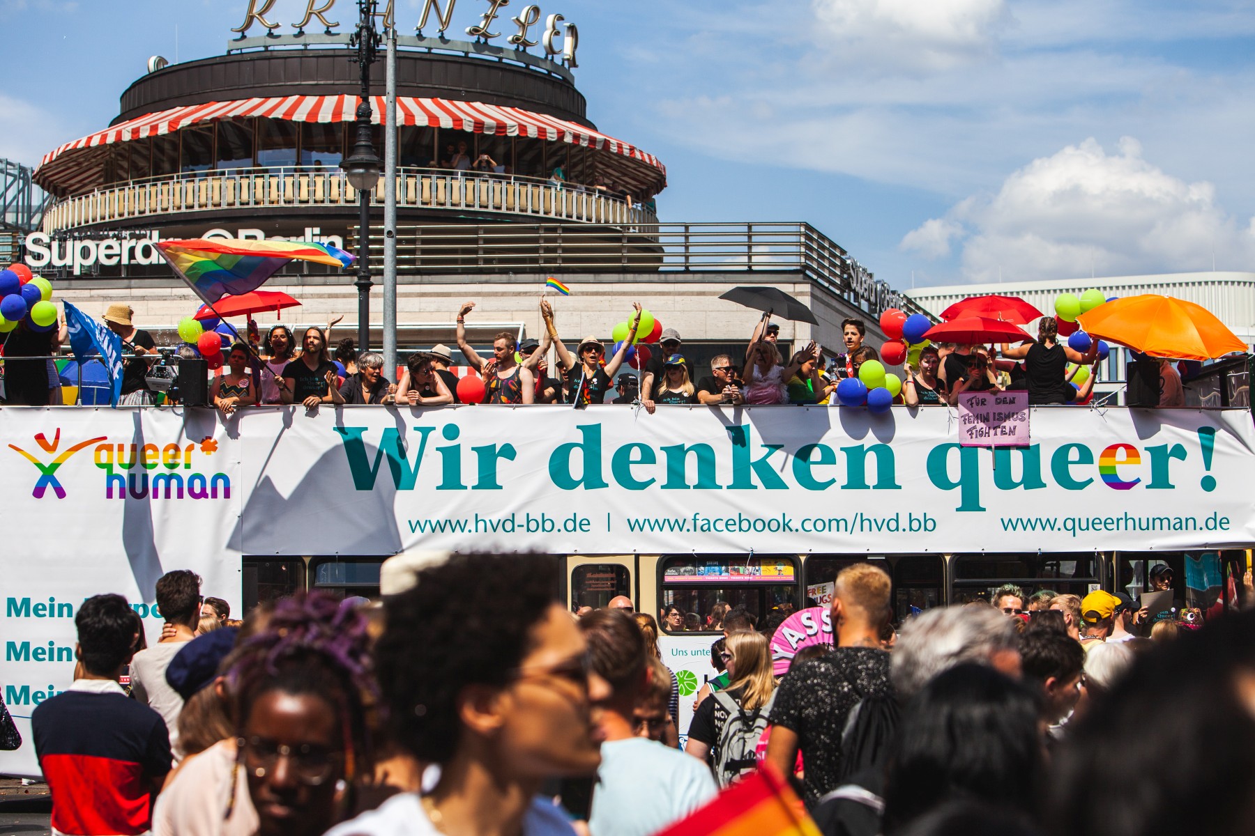 Auf einem Doppeldeckerbus und auf der Straßen davor feiern Teilnehmende der Parade am Berliner Christopher Street Day 2018.
